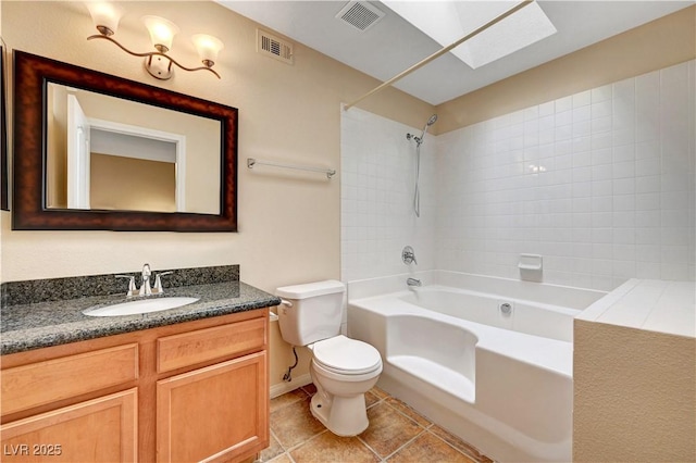 full bathroom with toilet, tile patterned flooring, a skylight, tiled shower / bath combo, and vanity