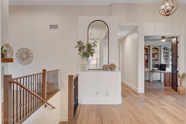 foyer entrance featuring light hardwood / wood-style floors and a notable chandelier