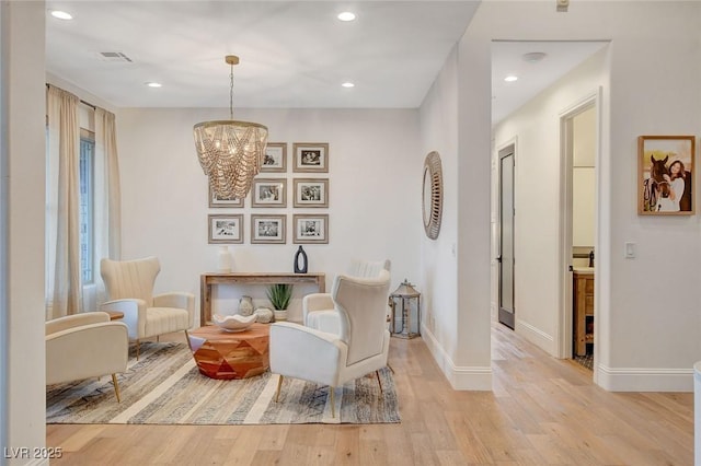 living area with a notable chandelier and light hardwood / wood-style floors