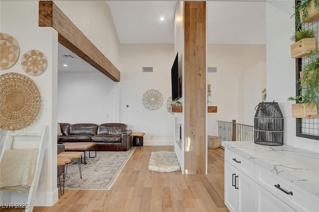 living room with a towering ceiling and light hardwood / wood-style floors