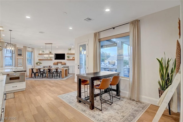 dining space with an inviting chandelier and light wood-type flooring