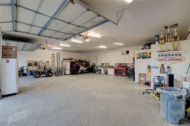 garage featuring white fridge and a garage door opener