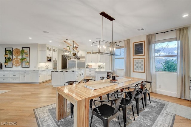 dining room with light wood-type flooring and a chandelier