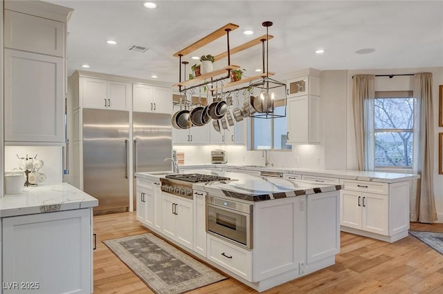 kitchen with a center island, light hardwood / wood-style flooring, and appliances with stainless steel finishes