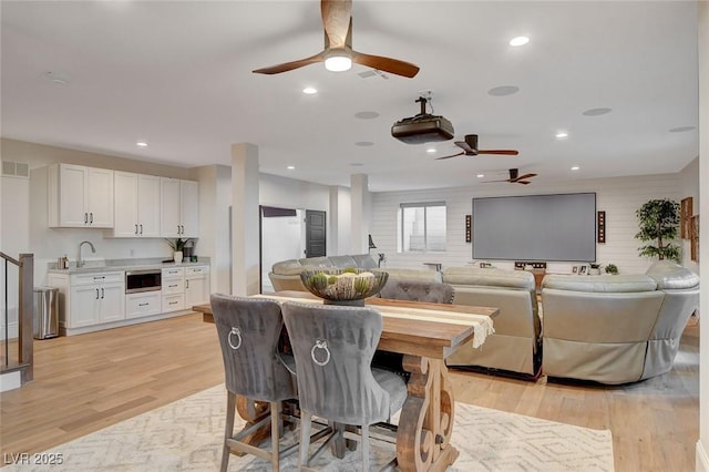 dining space with sink and light wood-type flooring