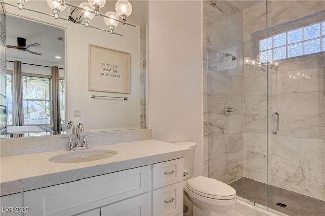 bathroom featuring ceiling fan with notable chandelier, toilet, walk in shower, and vanity