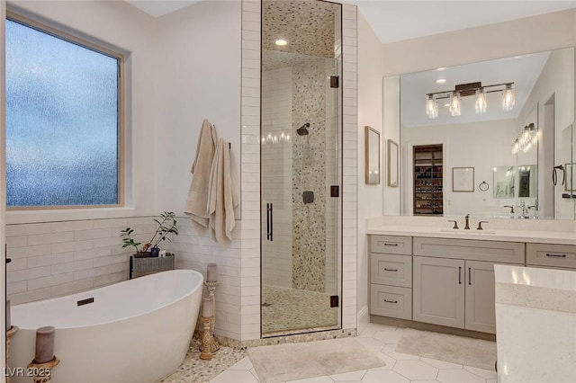 bathroom with tile walls, plus walk in shower, tile patterned floors, and vanity