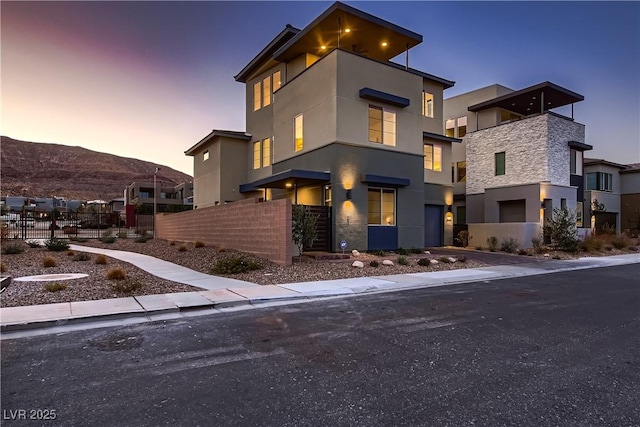 6289 Redstone Hills Dr, Las Vegas, NV 89148 - modern home featuring fence, stucco siding, stone siding, and a garage