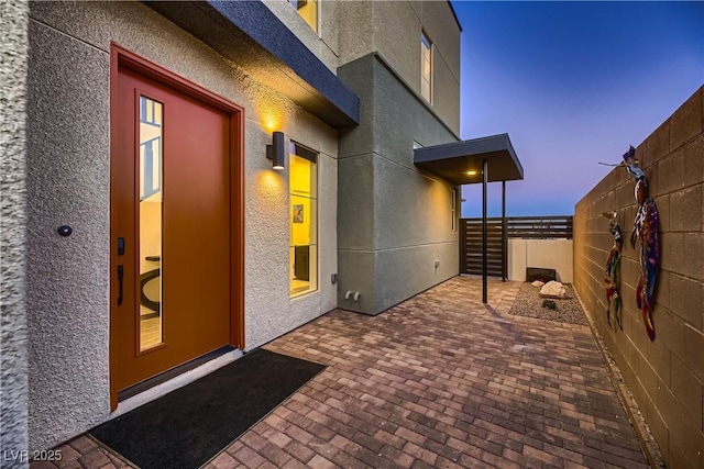 exterior entry at dusk with a patio