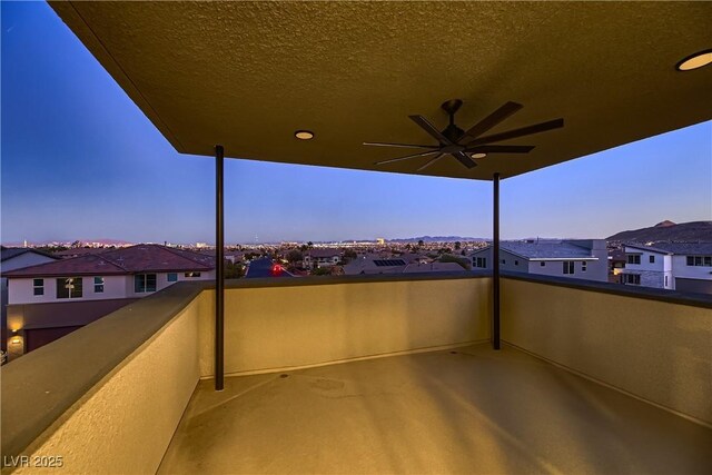 patio terrace at dusk with a balcony and ceiling fan