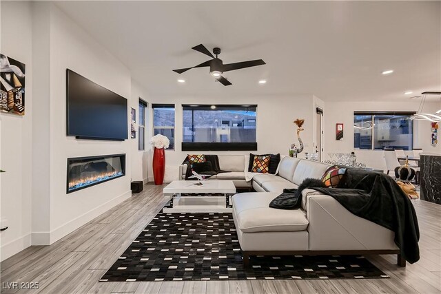 living room with ceiling fan and light wood-type flooring