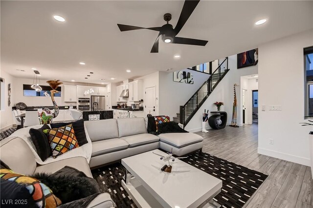 living room featuring ceiling fan, light hardwood / wood-style flooring, and sink