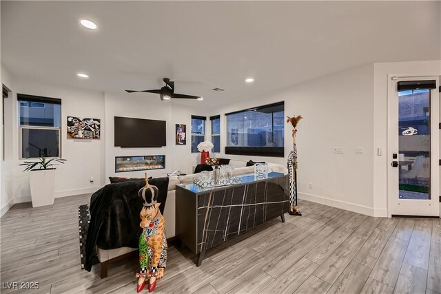 living room featuring light wood-type flooring and ceiling fan