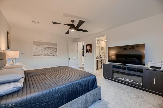 bedroom featuring ceiling fan, ensuite bathroom, and light carpet