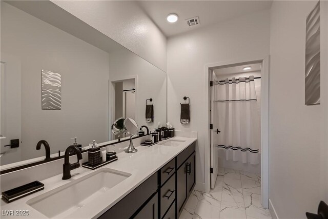 bathroom with curtained shower and vanity