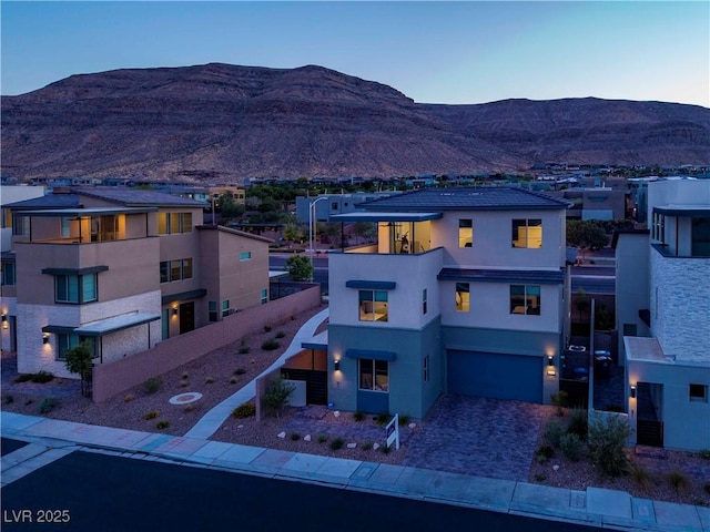 6289 Redstone Hills Dr, Las Vegas, NV 89148 - view of front of home featuring stucco siding, a garage, a mountain view, a balcony, and driveway