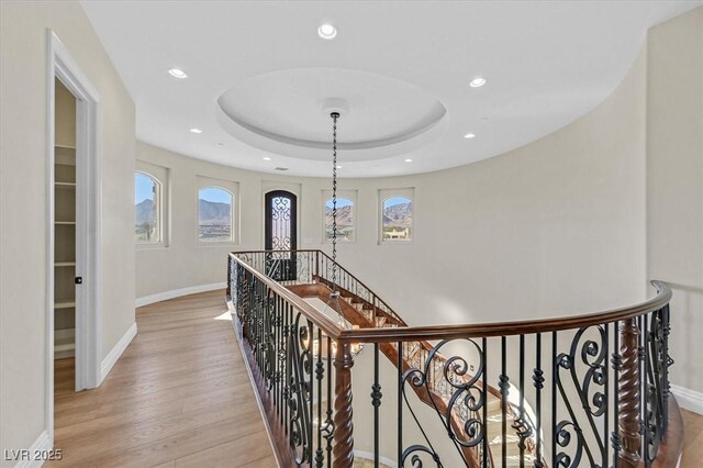 hallway featuring a raised ceiling and light wood-type flooring