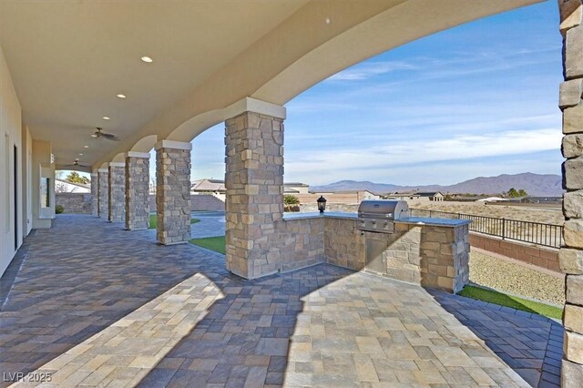 view of patio with area for grilling and a mountain view