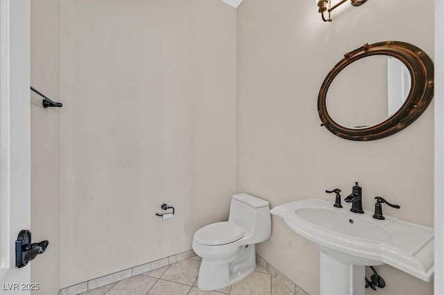 bathroom with tile patterned floors, toilet, and baseboards