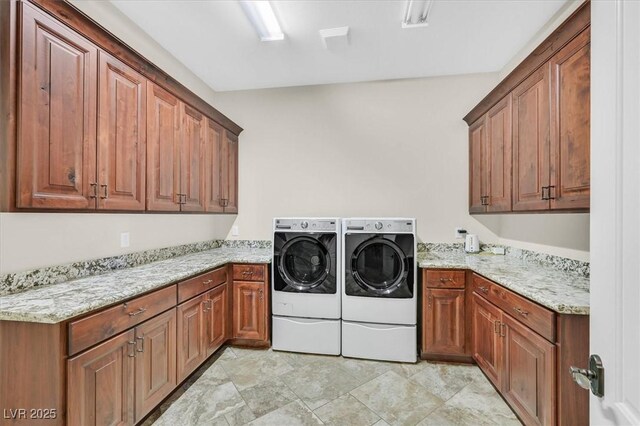 washroom featuring cabinets and washer and clothes dryer