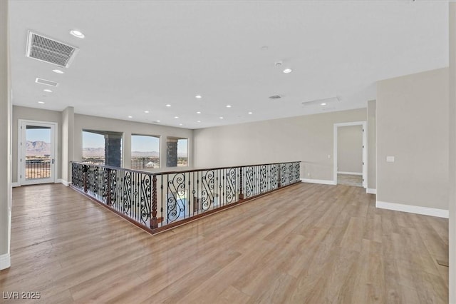 spare room featuring a wealth of natural light, visible vents, and light wood finished floors