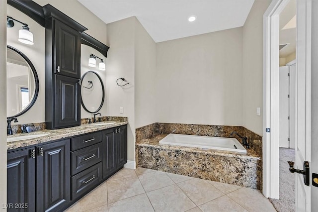 bathroom featuring vanity, tile patterned flooring, and a relaxing tiled tub