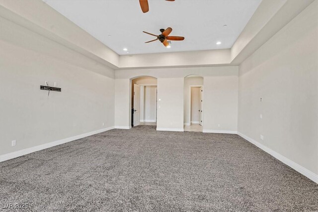 carpeted empty room featuring ceiling fan and a tray ceiling