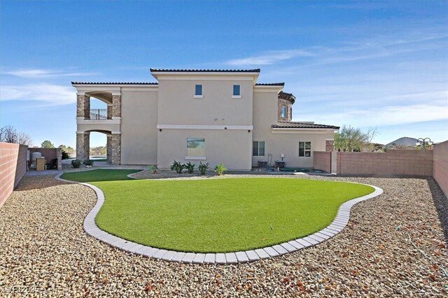 rear view of house featuring a yard and a balcony