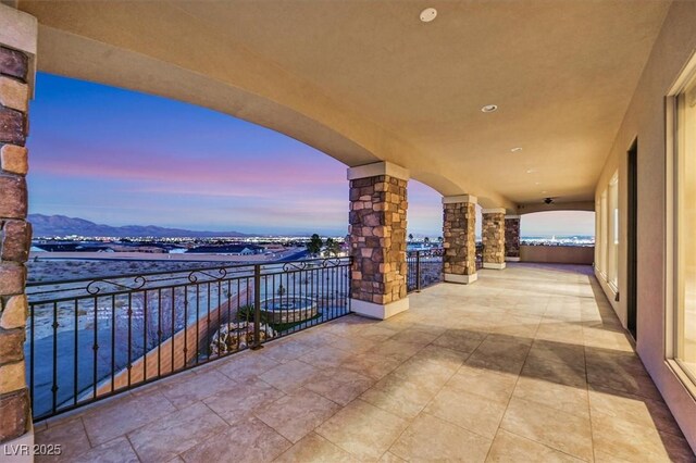 balcony at dusk featuring a mountain view