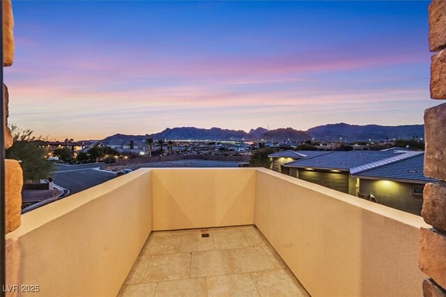 balcony at dusk featuring a mountain view