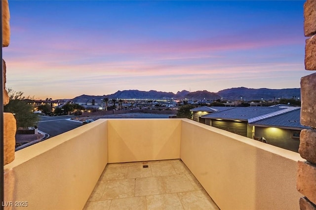 balcony at dusk featuring a mountain view