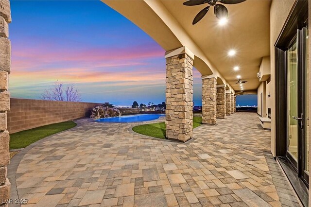 patio terrace at dusk with pool water feature and ceiling fan