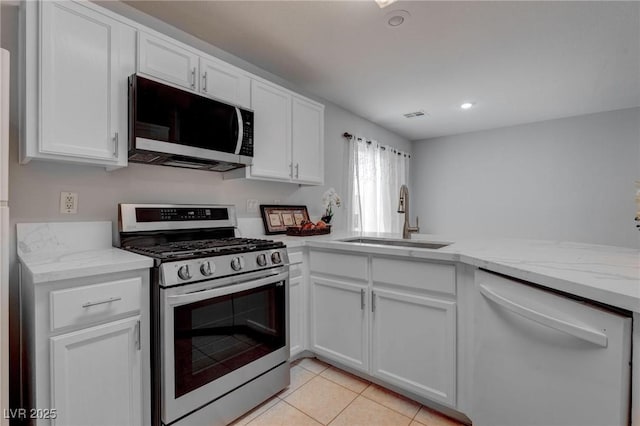 kitchen featuring sink, white cabinetry, light tile patterned floors, and appliances with stainless steel finishes