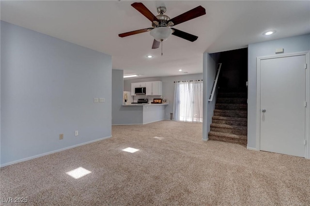 unfurnished living room featuring ceiling fan and light carpet