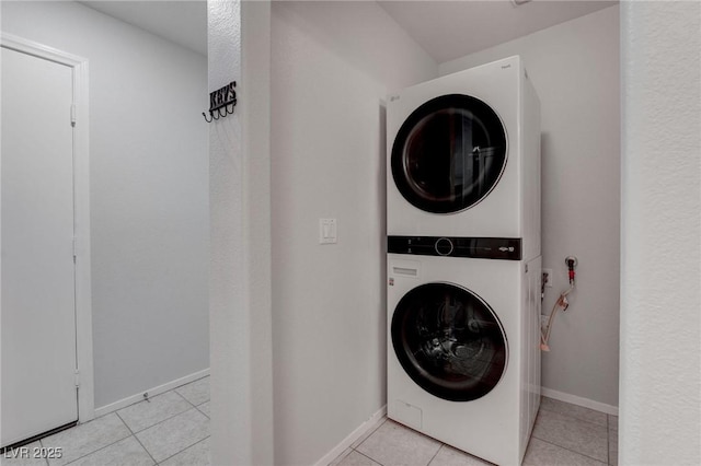 laundry room with stacked washer / drying machine and light tile patterned floors