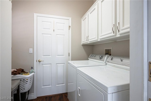 laundry room featuring dark wood-type flooring, cabinets, and washer and clothes dryer