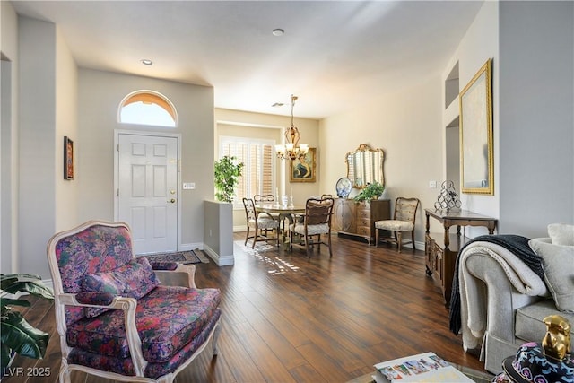 foyer with dark hardwood / wood-style floors and a notable chandelier