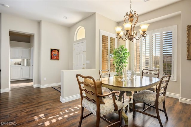 dining room with dark hardwood / wood-style flooring and an inviting chandelier