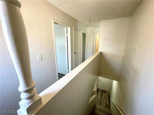 staircase featuring a textured ceiling