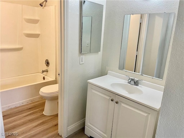 full bathroom featuring toilet, vanity, hardwood / wood-style floors, and tub / shower combination