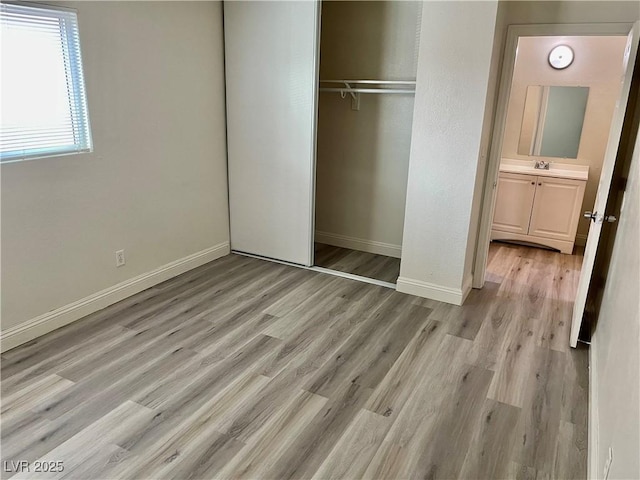 unfurnished bedroom with a closet and light hardwood / wood-style flooring