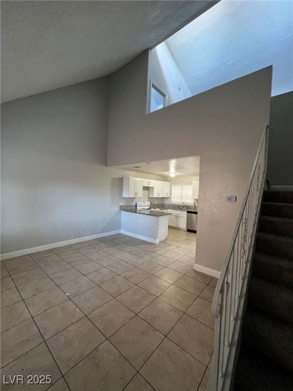 unfurnished living room with a high ceiling and light tile patterned floors