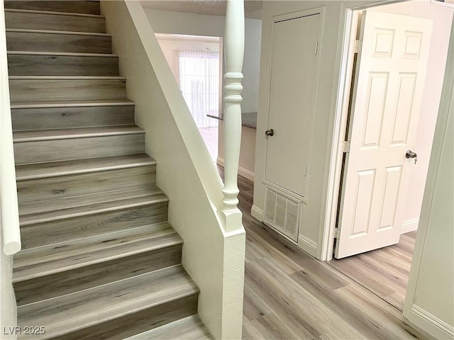 stairs with hardwood / wood-style floors