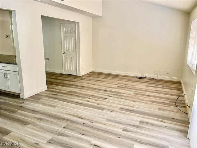 spare room featuring a textured ceiling and light hardwood / wood-style floors