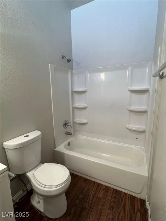 full bathroom with toilet, hardwood / wood-style flooring,  shower combination, and vanity