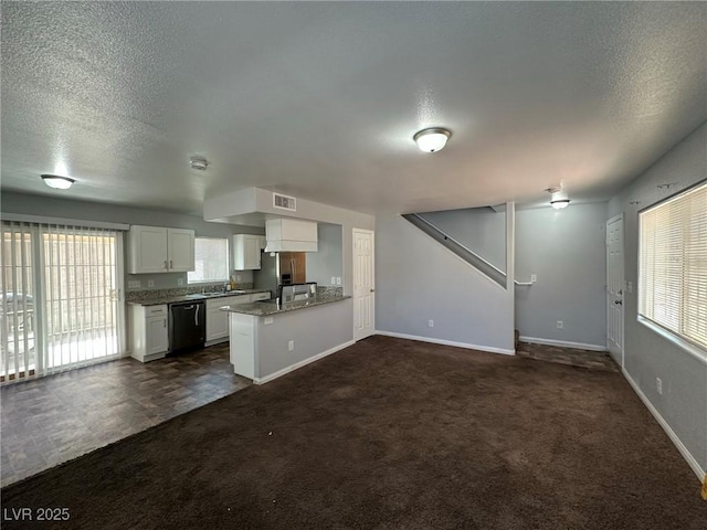 kitchen with dishwasher, dark colored carpet, kitchen peninsula, light stone counters, and white cabinets