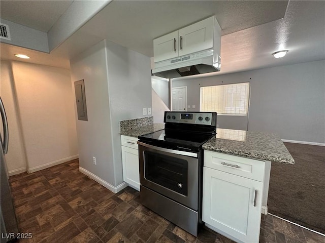 kitchen featuring kitchen peninsula, white cabinets, dark stone counters, and electric stove