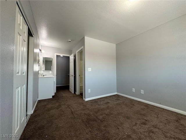 empty room with a textured ceiling and dark colored carpet