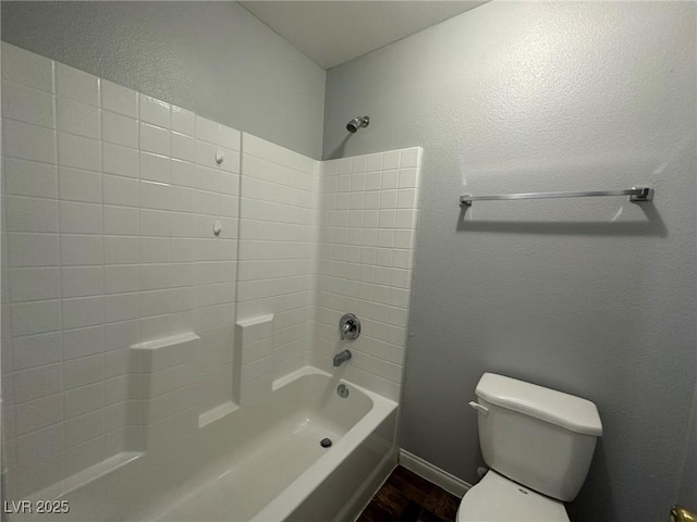 bathroom with bathtub / shower combination and toilet