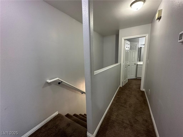 hallway featuring dark carpet